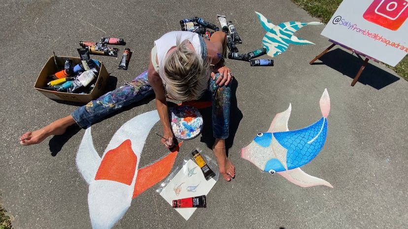 Sally Martin paints fish at Echo Farms Park in an area that usually floods. (Spectrum News 1/Natalie Mooney)